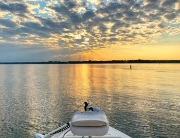 fishing boat with sunset in background