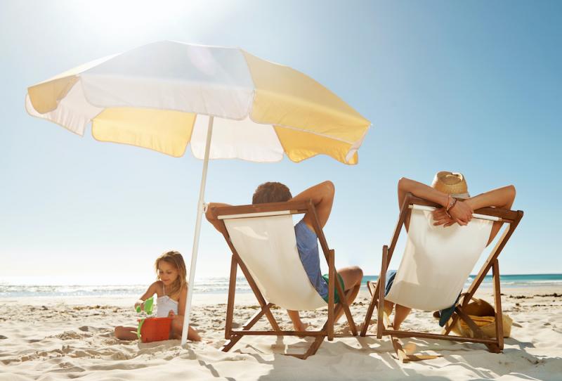 Family sitting on beach chairs by the ocean